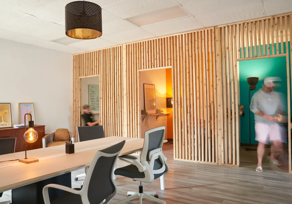The studio's shared desks and the slatted wood wall.