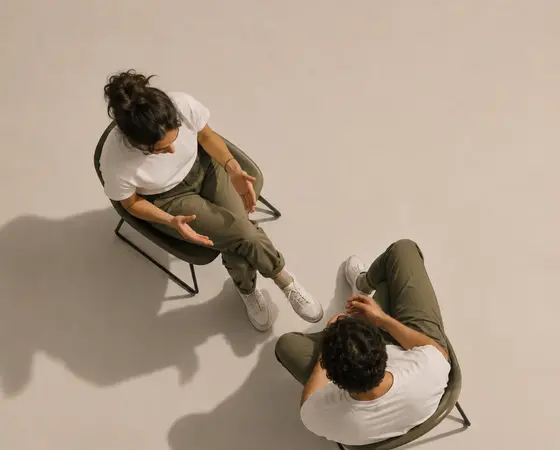 Two people sitting across from each other, talking it through.